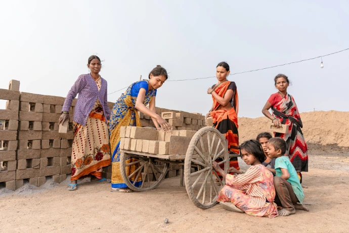a group of women standing around a wooden cart